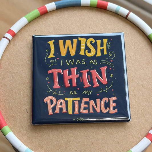 A square tin with a colorful striped rim sits on a round cardboard insert. The center of the tin features a dark navy background with the hand-lettered quote 'I WISH I WAS AS THIN AS MY PATIENCE'.